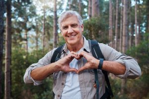 Joyful senior making a heart sign with his hands